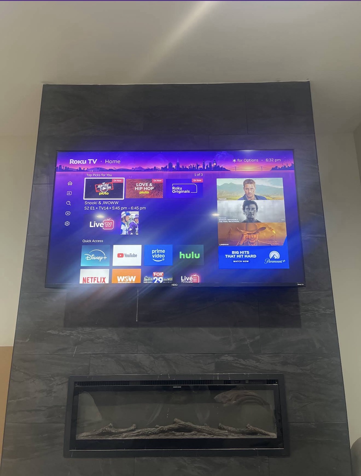 Dark marble slab accent wall with mounted TV